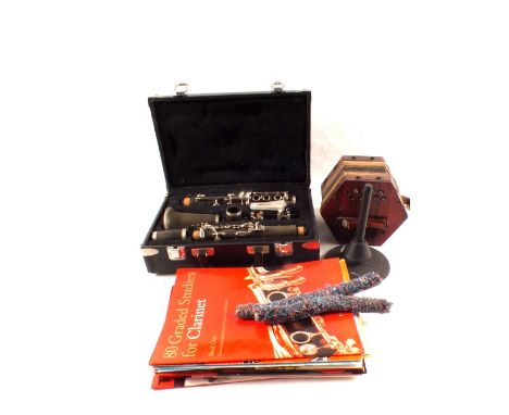 A cased clarinet, books and stand plus an accordion