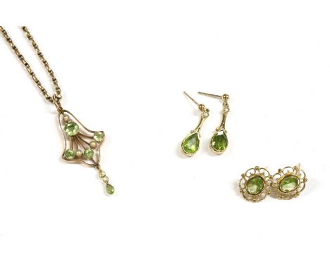 An Edwardian peridot and split pearl open scroll pendant, with pearl and peridot drop suspended on a gold belcher chain (test