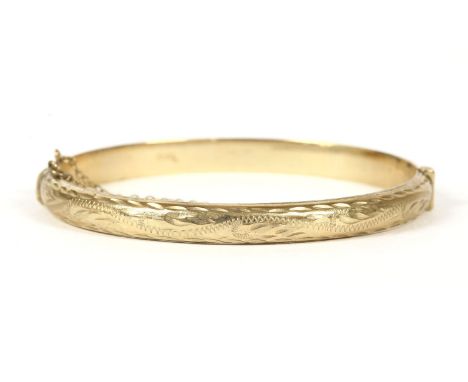 A 9ct gold hollow hinged bangle, with engraved D-shaped top section, 8.63g