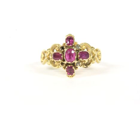 A Victorian gold ruby and diamond cluster ring, a central mixed oval cut ruby, claw set, with four further mixed oval cut rub