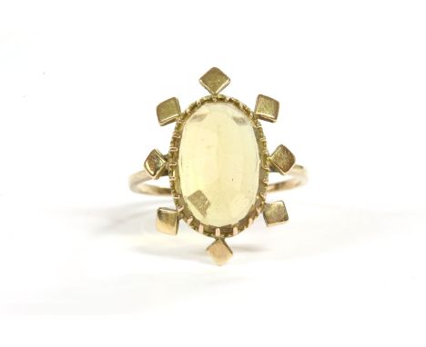 A 9ct gold single stone oval cheque cut citrine ring, claw set to a border of square beads with split shoulder to a plain pol