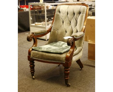A Victorian rosewood open armchair, with upholstered button back, with scrolled arms and stylised leaf legs on brass castors,