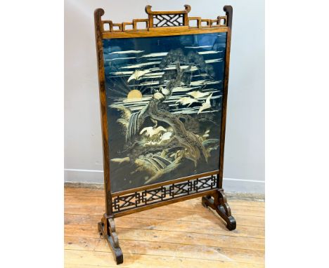 A handsome Chinese rosewood framed firescreen, c. 1900/1920, with trellis and interlocking pierced top and bottom panel with 
