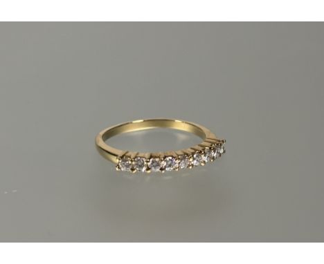 A diamond half hoop eternity ring, the nine uniform round brilliant-cut stones claw-set on an 18ct yellow gold band. Total di