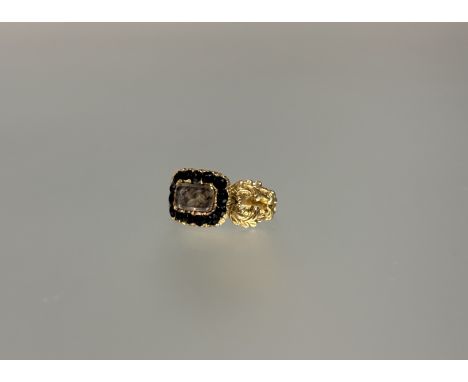 A mourning ring, second quarter of the 19th century, the central glazed hair-inset locket within a band of black glass "stone