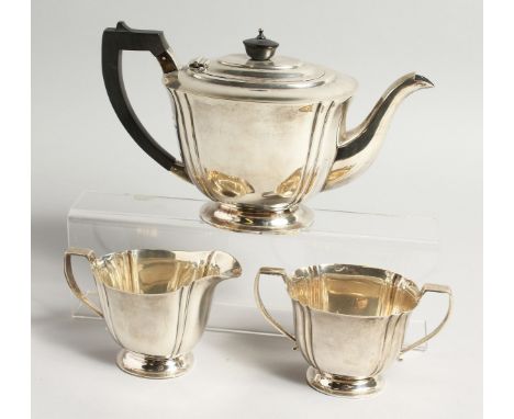 A THREE PIECE SILVER TEA SET comprising tea pot with ebony handle, sugar basin and milk jug. Birmingham 1910, weighs 30ozs.