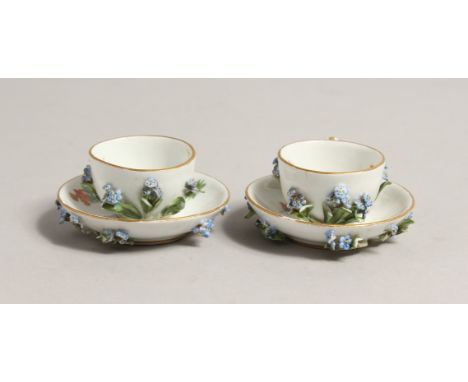 A MINIATURE PAIR OF 19TH CENTURY MEISSEN ENCRUSTED CUPS AND SAUCERS. Cross swords mark in blue.