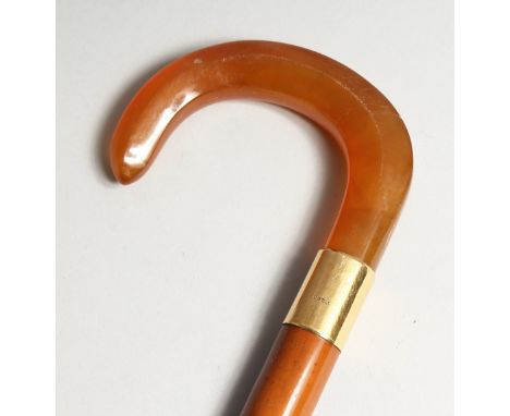 A GOOD AMBER WALKING STICK  with 18ct gold band