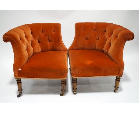 A pair of Victorian button back corner chairs on turned mahogany legs and brass casters, salmon pink upholstery, 80cm high x 