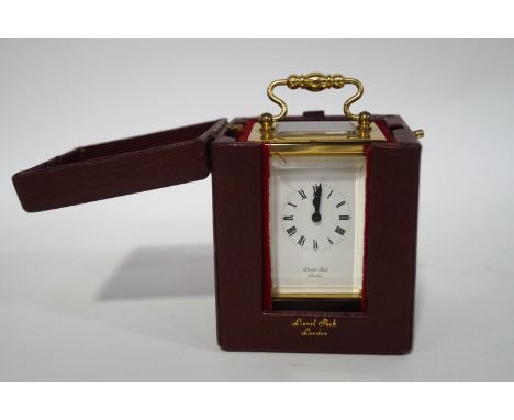 A miniature brass carriage clock, the dial signed Lionel Peck, with leather case and winding key, 10cm high including carryin