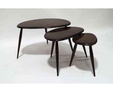 An Ercol pebble nest of three tables, on turned tapering legs, 40cm high x 65cm wide x 43cm deep, with label to underside