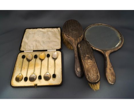 A silver three piece silver dressing table set, comprising a hand mirror, hair brush and a clothes brush; with a set of six s