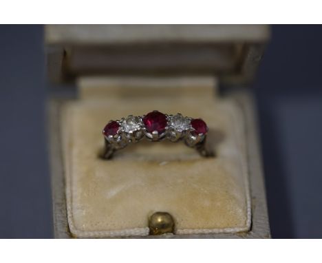 A diamond and ruby five stone ring, the white mount stamped '9ct', the three graduated oval cut rubies with an old brilliant 