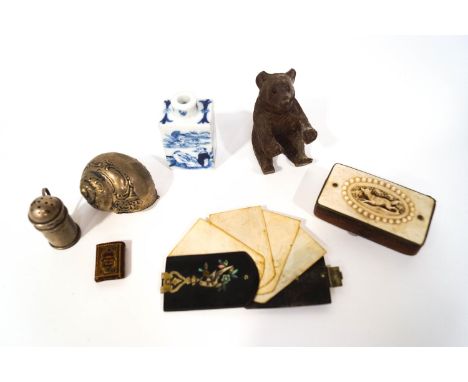 A collection of miniature items: silver pounce pot, 3.5cm high, a Black Forest bear, a brass snuff box, leather covered with 