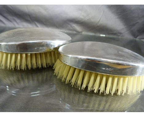 Pair of unused silver hallmarked clothes brushes with engine turned decoration, dated 1946