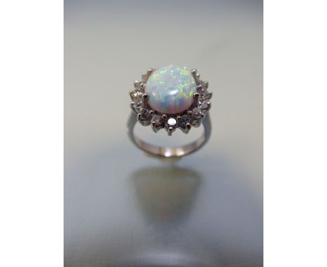 Silver ring with large central opal surrounded by CZs in a daisy style