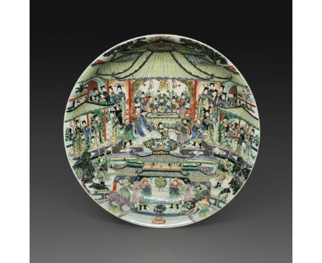 IMPORTANT PLATen porcelaine et émaux polchromes dans le style de la famille verte, à décor d'une scène de palais, animée d'un