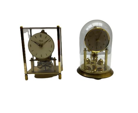 A 20th century English Torsion clock marketed by Bentime Ltd, London, with a four-ball rotary pendulum, white dial with gilt 