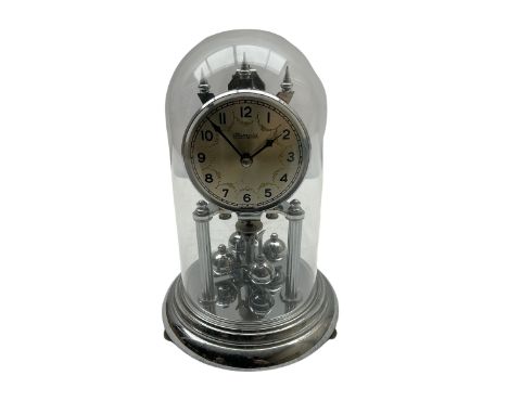 A 20th century German "Olympia" torsion suspension clock, with a silver effect base and four ball rotary pendulum, silver eff