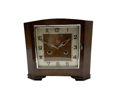 A 1930'S Art Deco 8-day striking mantle clock in a rectangular oak case on raised feet, with a corresponding square dial, hou