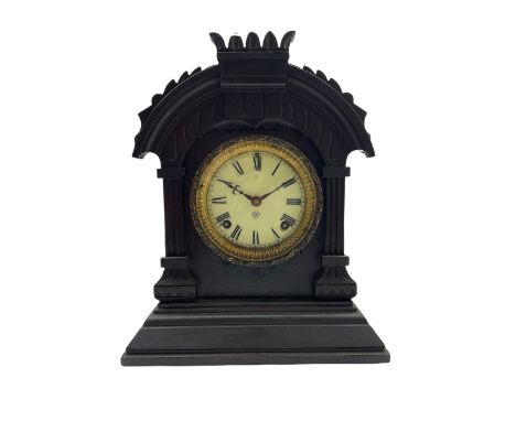 An American Ansonia 8-day striking mantle clock c1880 in a carved ebonised wooden case, with a cream enamel dial, Roman numer