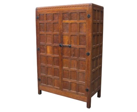 A 1930's Robert 'Mouseman' Thompson Oak Two Door Wardrobe, with arcaded frieze, adzed panelled doors and sides, internally wi