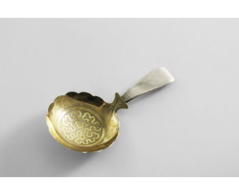 AN GEORGE III PARCELGILT CADDY SPOON with a shaped circular bowl, engraved in the centre with a wrigglework ribbon against a 