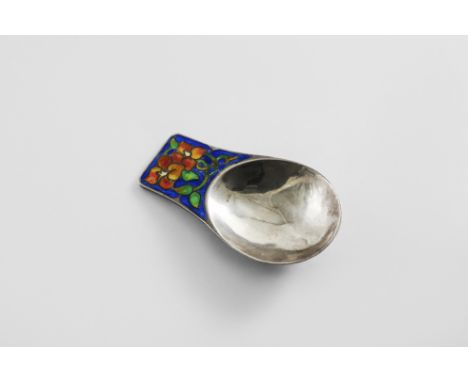 AN EARLY 20TH CENTURY HANDMADE CADDY SPOON with a lug handle, decorated with blue, green, orange and pink enamel leaves and t