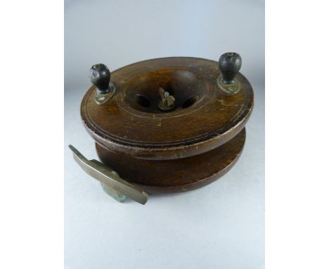 An unnamed Vintage 6in. wooden fly fishing reel with turned wooden handle and brass foot.