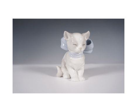 This delightful Nao by Lladro figurine, model number 01348, is titled "Kitty Present" and features a seated cat adorned with 