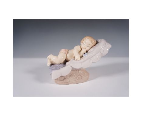 Charming Nao by Lladro porcelain figurine titled Sleepy Baby in Shell, model number 1609. This delicate handcrafted piece cap
