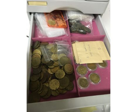 A plastic cabinet with five drawers containing an interesting collection of coin and other tokens. Including a large collecti