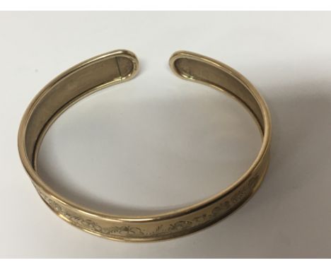 A 9carat gold bangle with floral engraved pattern weight 9g