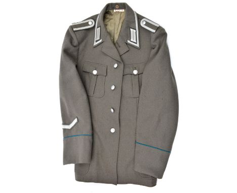 A post war German NCO’s tunic, light grey with silver collar patches, epaulettes, etc; also 8 various East German officer’s p