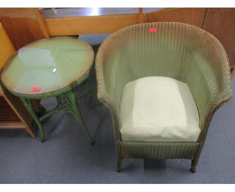 A Lloyd Loom green painted armchair with upholstered drop-in seat, and a green Lloyd Loom occasional table with circular glas