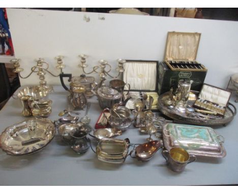 A large mixed lot of silver plate to include candelabras, entrée dish, serving ladle, teapots, cutlery and other itemsLocatio