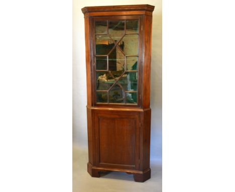 A 19th Century Mahogany Standing Corner Cabinet, the moulded top above astragal glazed door enclosing shelves, the lower sect