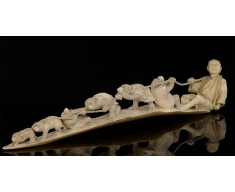 Late 19th/early 20th century Japanese carved ivory group of six monkeys playing tug-of-war with a man sitting on the ground, 