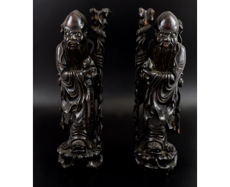 Pair of Chinese carved hardwood figures of Shou Lao holding a peach and staff,PLEASE NOTE: THIS ITEM CONTAINS OR IS MADE OF I