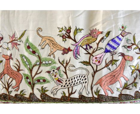  A Persian silk  bed cover with central extensive polychrome embroidery depicting birds and animals in a wooded landscape wit