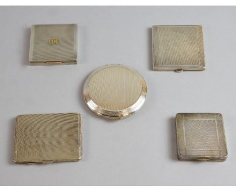 Asprey a silver compact with gold monogram, London 1940, and four other silver or white metal compacts .  All items in good c