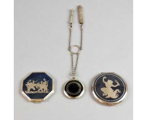 Black enamel chatelaine compact and two niello decorated white metalcompacts .  