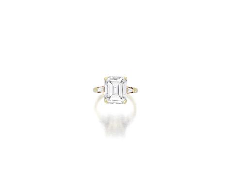 A diamond ringcentering an emerald-cut diamond, weighing 5.85 carats, flanked by tapered baguette-cut diamonds; mounted in 18