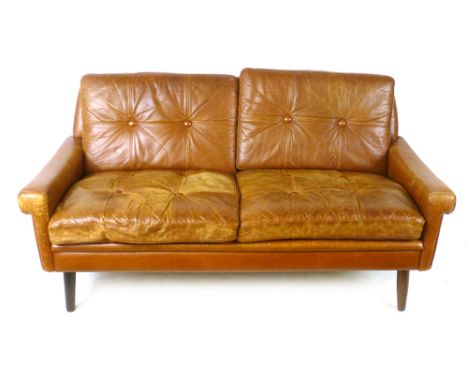 A 1970's tan leather and button backed two-seater sofa on mahogany circular tapering legs by Skippers Mobler, l. 148 cm CONDI