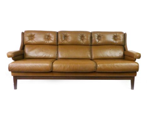 A Danish 1970's brown leather three-seater sofa with raised armrests on mahogany square tapering legs, l.206 cm 