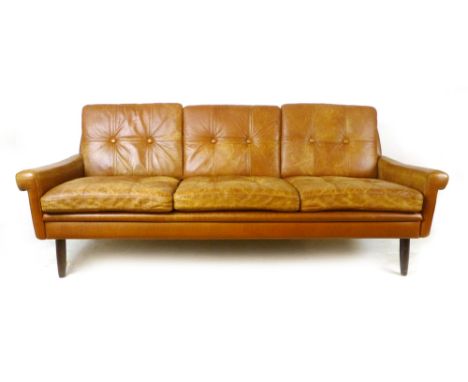 A 1970's tan leather and button backed three seater sofa on mahogany circular tapering legs, l. 182 cm CONDITION REPORT: Stru