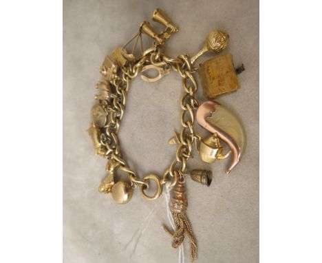 A 9ct gold curb link charm bracelet set with approximately seventeen mainly gold or gold coloured charms, including a miniatu