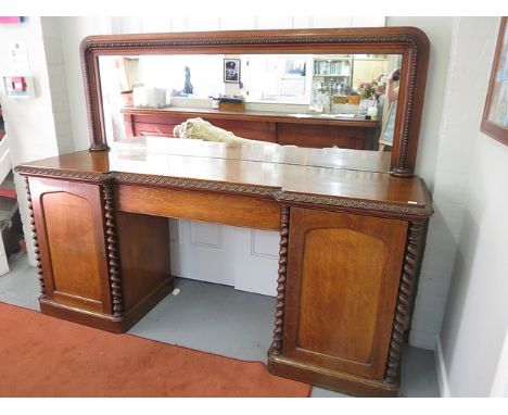 Victorian mahogany pedestal sideboard with mirrored back, carved and moulded edge over a central drawer flanked by barley twi