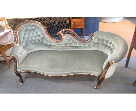 A late Victorian mahogany carved, framed and upholstered sofa with scrolled end arms, with kneed carved cabriole legs with ce