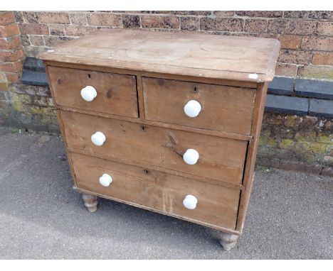 A VICTORIAN STRIPPED PINE CHEST OF DRAWERS with white ceramic handles (in need of some restoration) 84cm wide